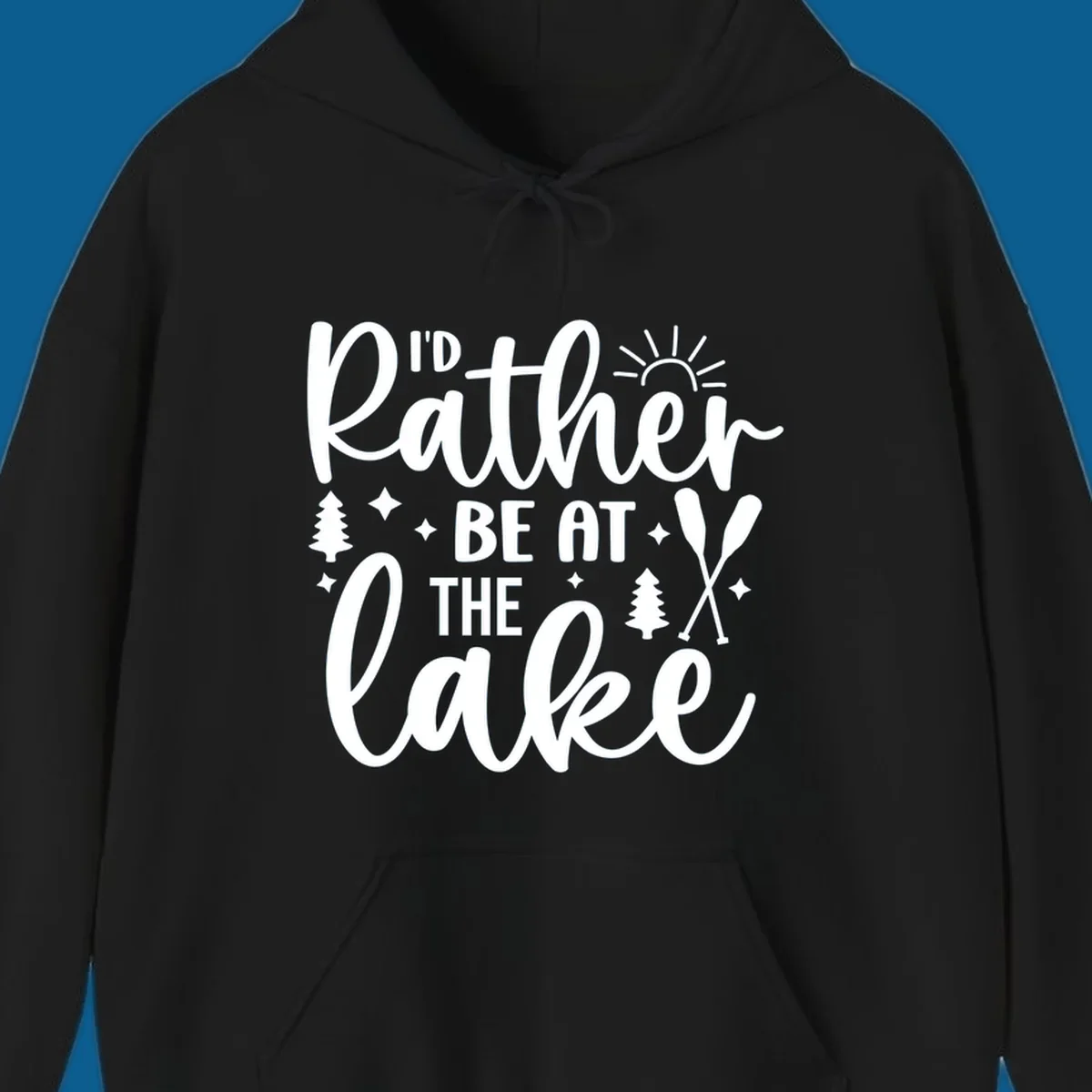 I'd Rather Be At The Lake typography design with sun rays, trees, and oars.