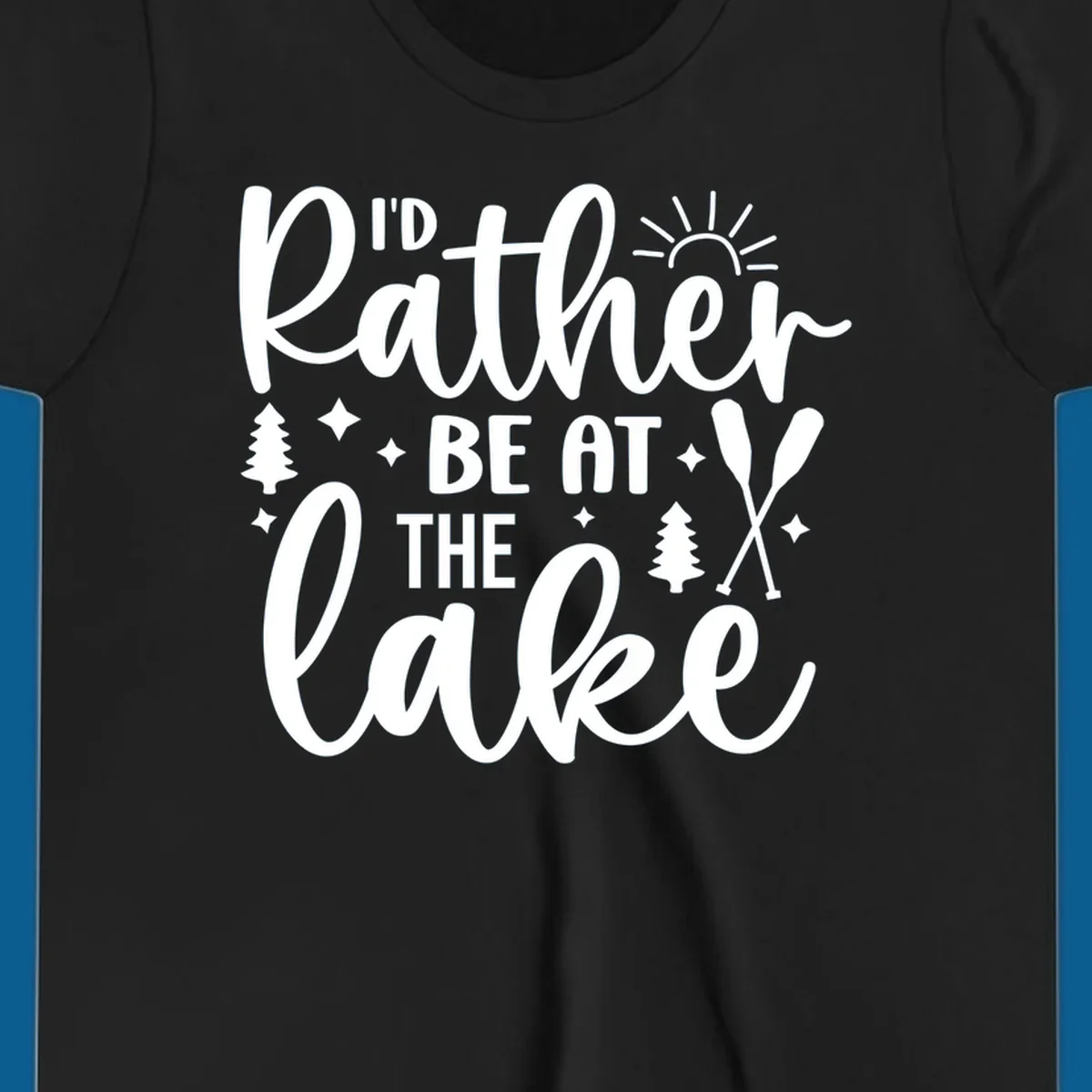 I'd Rather Be At The Lake typography design with sun rays, trees, and oars.