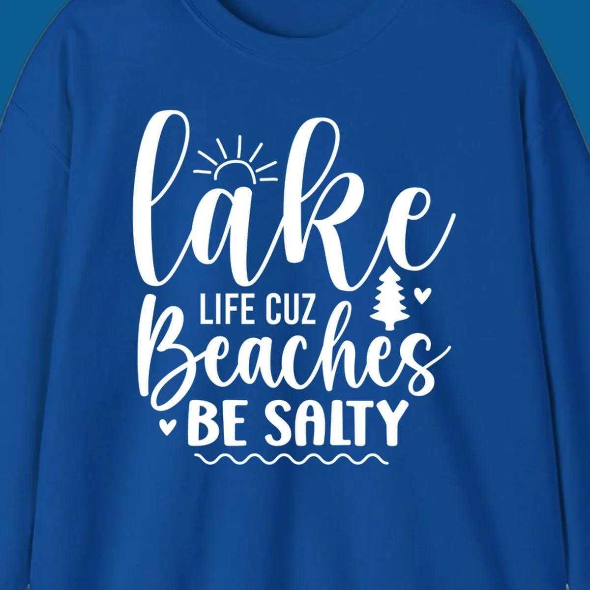 Lake life cuz beaches be salty text design with sun and tree elements.