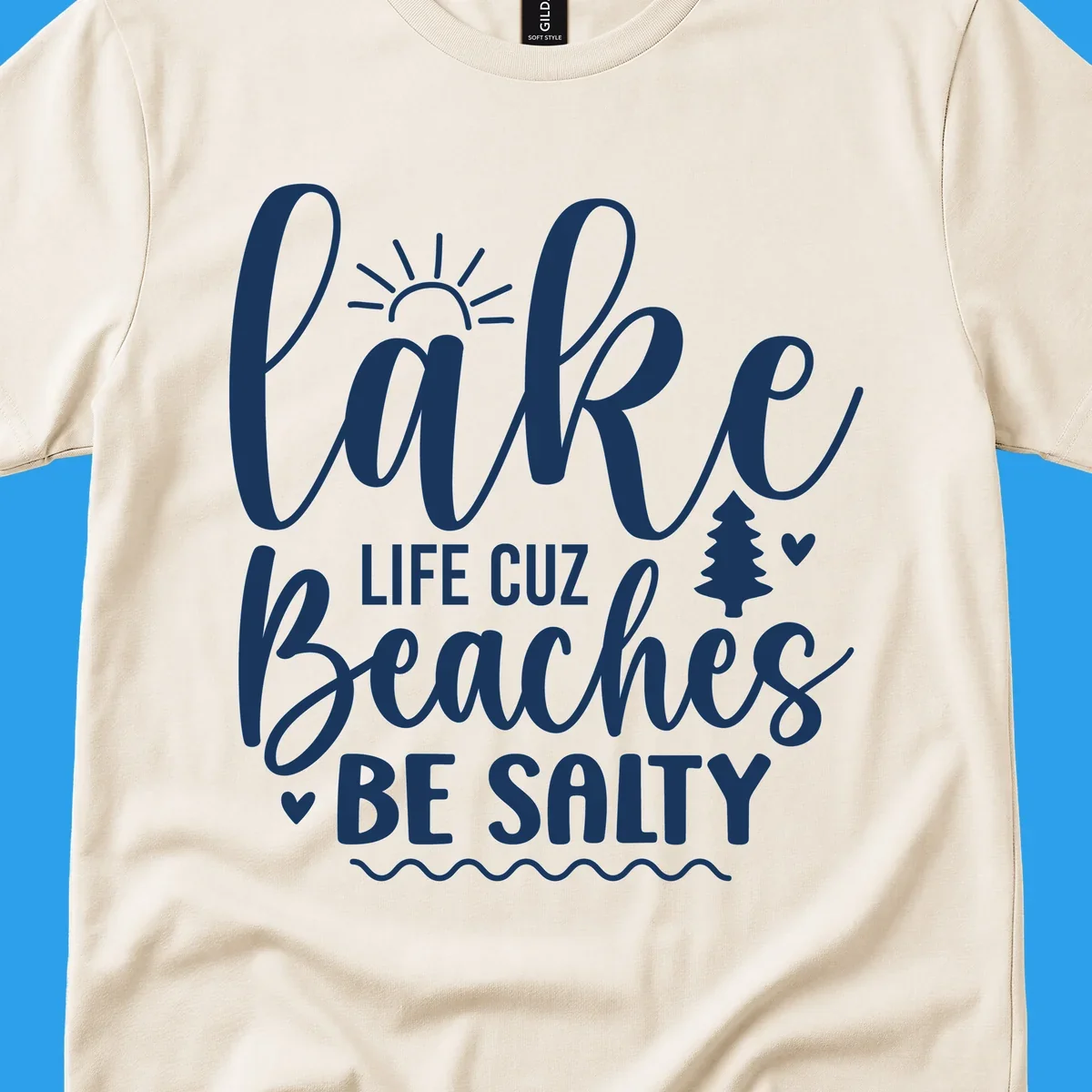 Lake life cuz beaches be salty text design with sun and tree elements.
