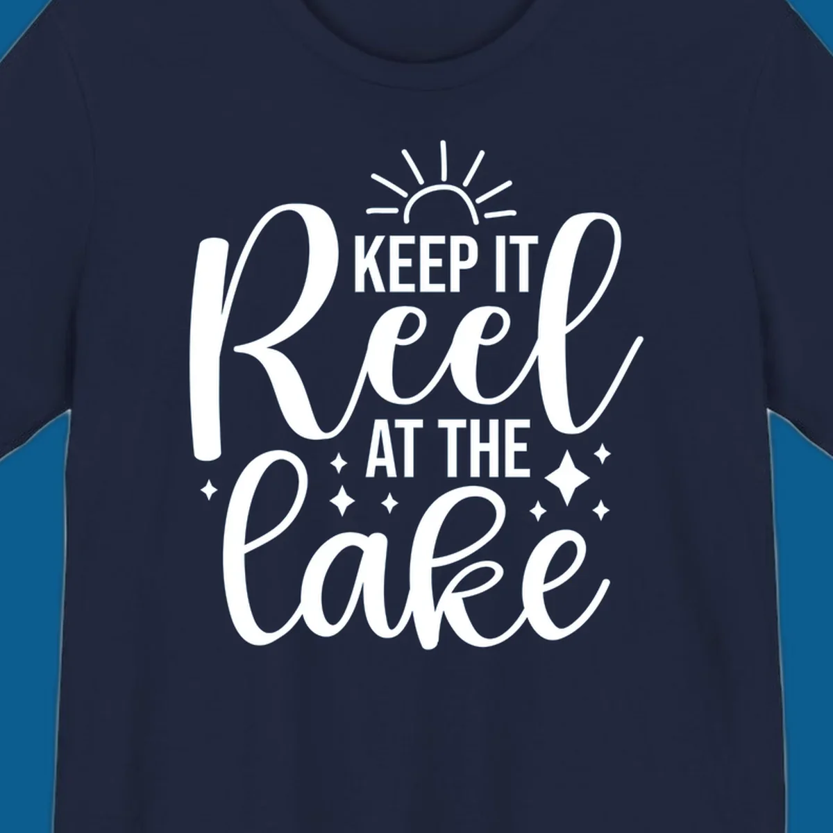 Keep It Reel At The Lake design with sun rays and sparkles, a lakeside lifestyle graphic.