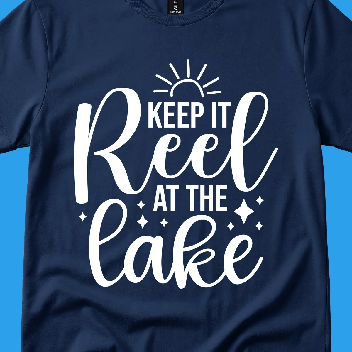 Keep It Reel At The Lake design with sun rays and sparkles, a lakeside lifestyle graphic.