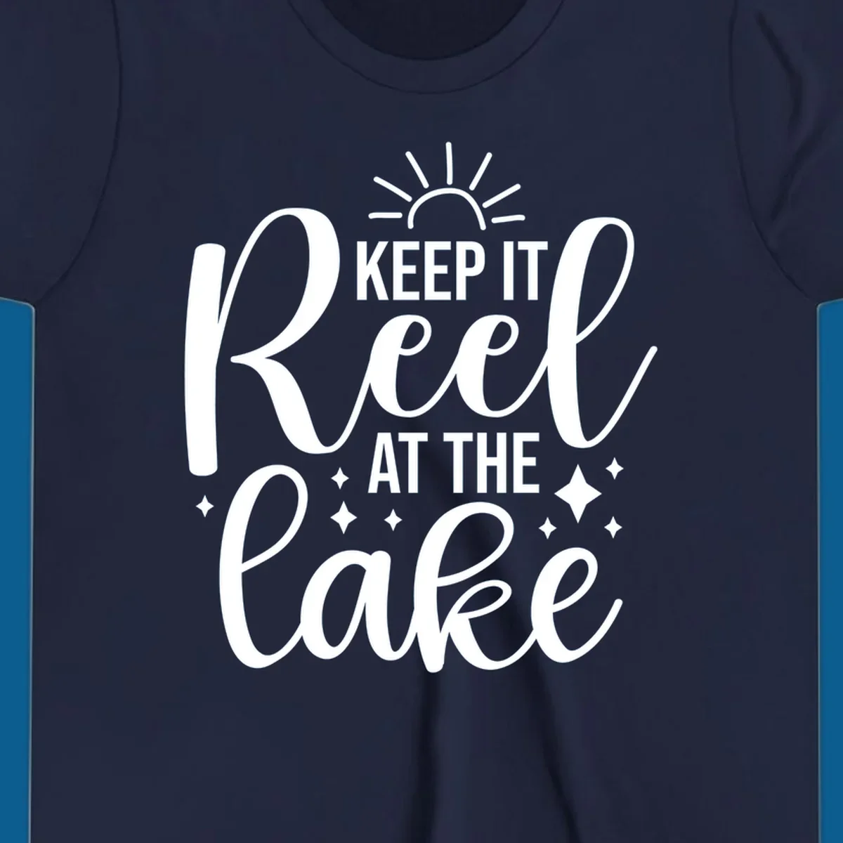 Keep It Reel At The Lake design with sun rays and sparkles, a lakeside lifestyle graphic.
