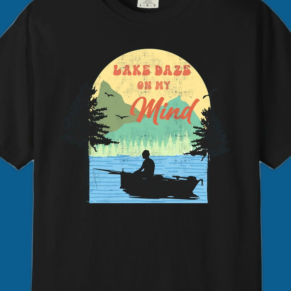 Lake daze fishing design featuring a person in a boat on a lake with trees and mountains.