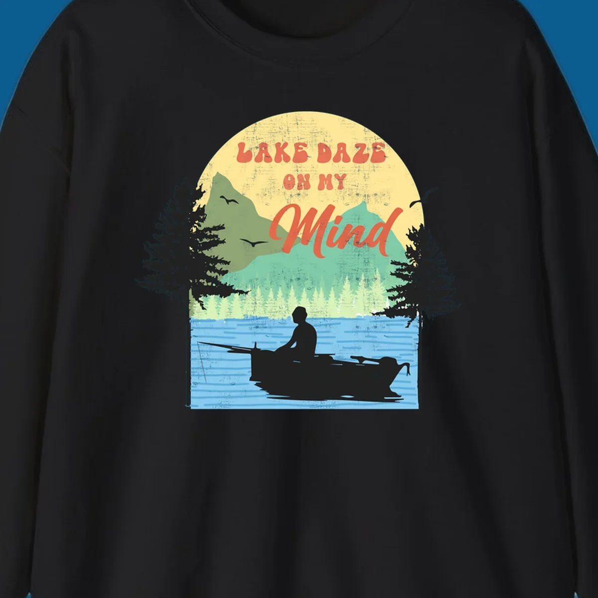 Lake daze fishing design featuring a person in a boat on a lake with trees and mountains.