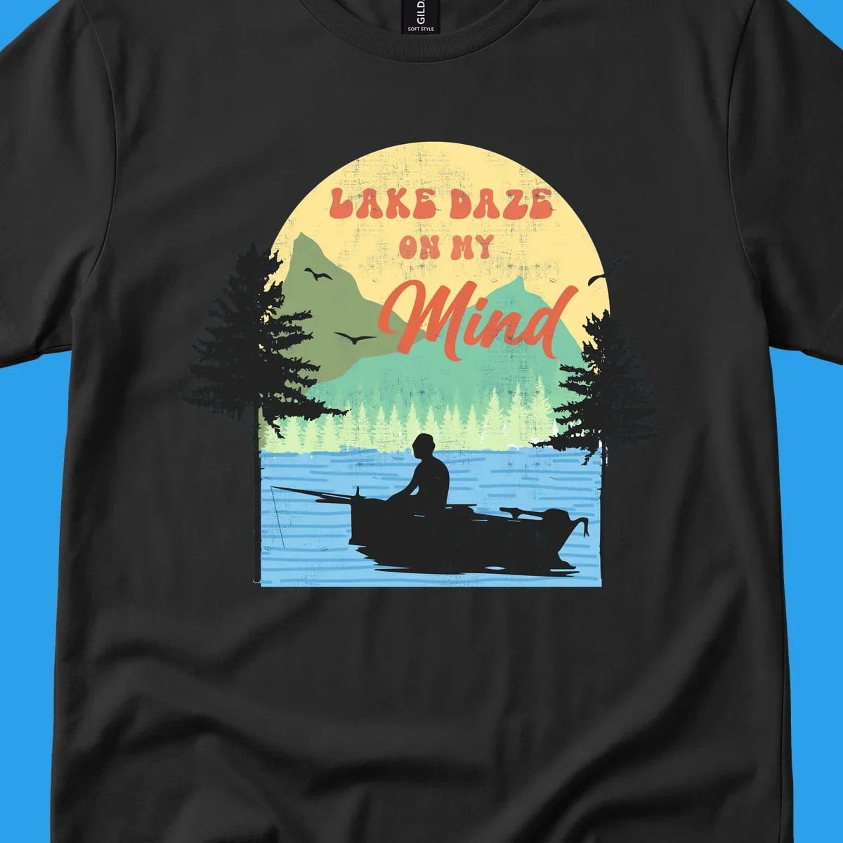 Lake daze fishing design featuring a person in a boat on a lake with trees and mountains.