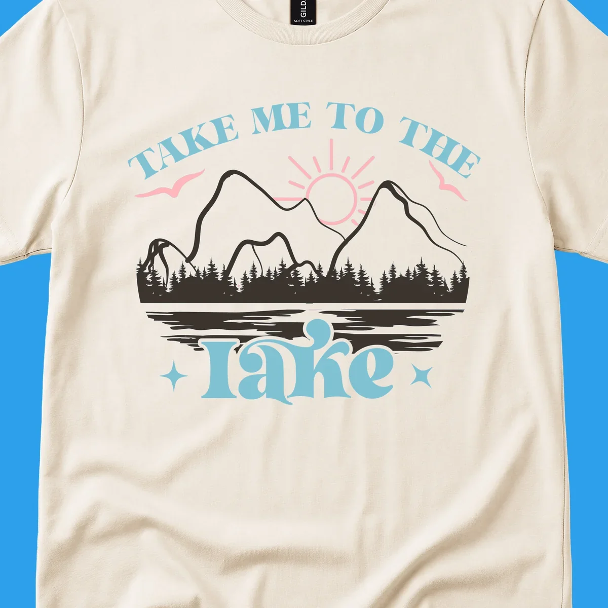 Illustration of mountains, lake, sun, and birds with text 'Take Me To The Lake'.