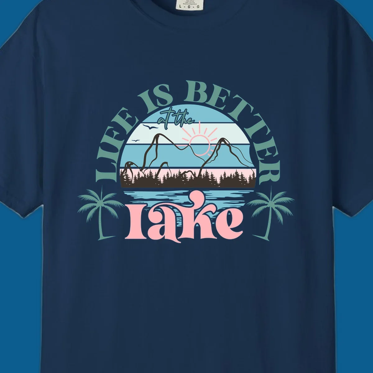 Life is better at the lake scenic design with mountains, trees, lake, and palm trees.