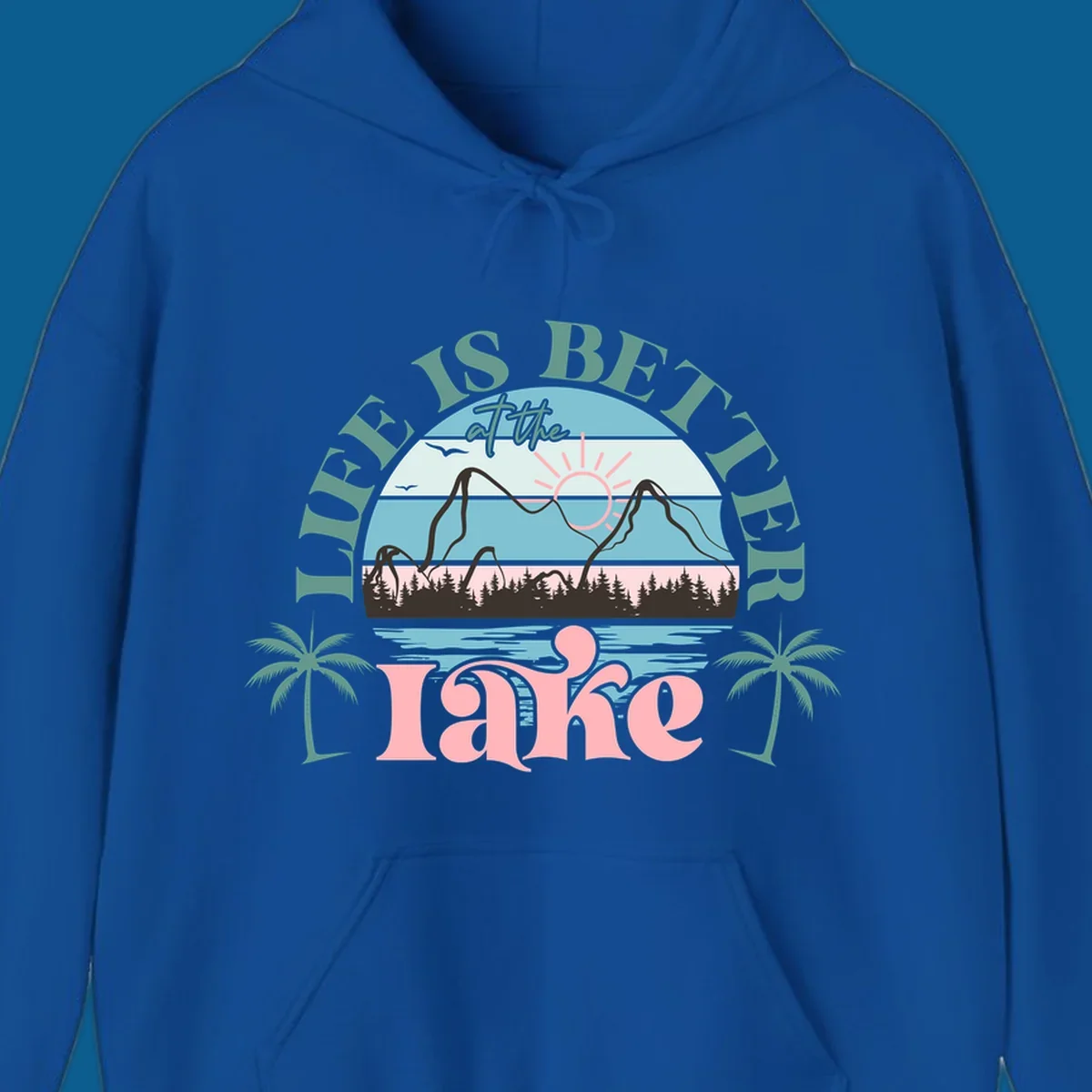 Life is better at the lake scenic design with mountains, trees, lake, and palm trees.