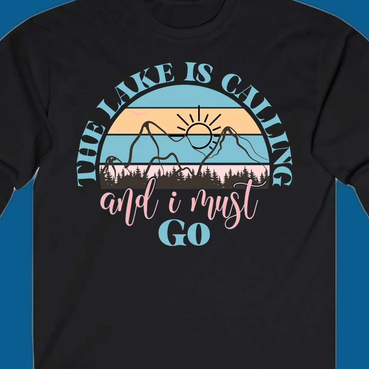 The Lake Is Calling And I Must Go text with mountain and sunset illustration.