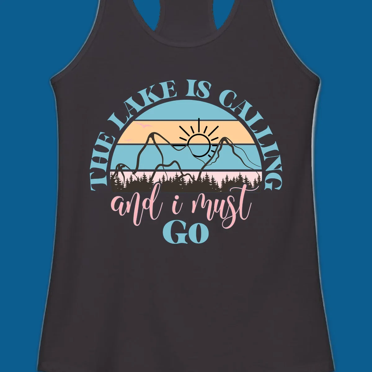 The Lake Is Calling And I Must Go text with mountain and sunset illustration.