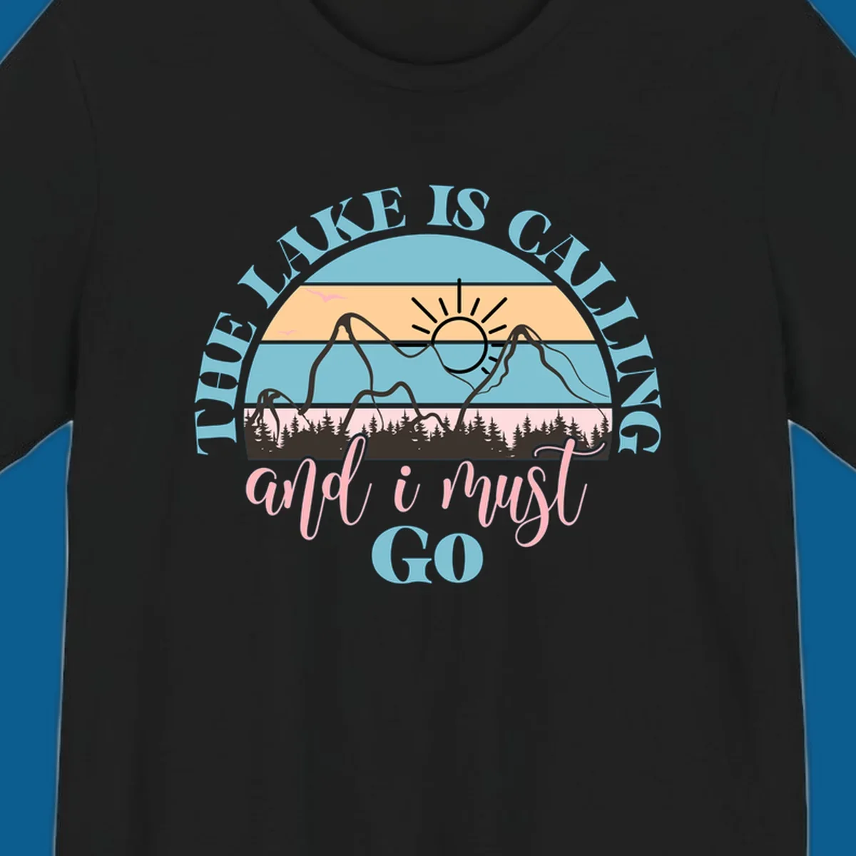 The Lake Is Calling And I Must Go text with mountain and sunset illustration.