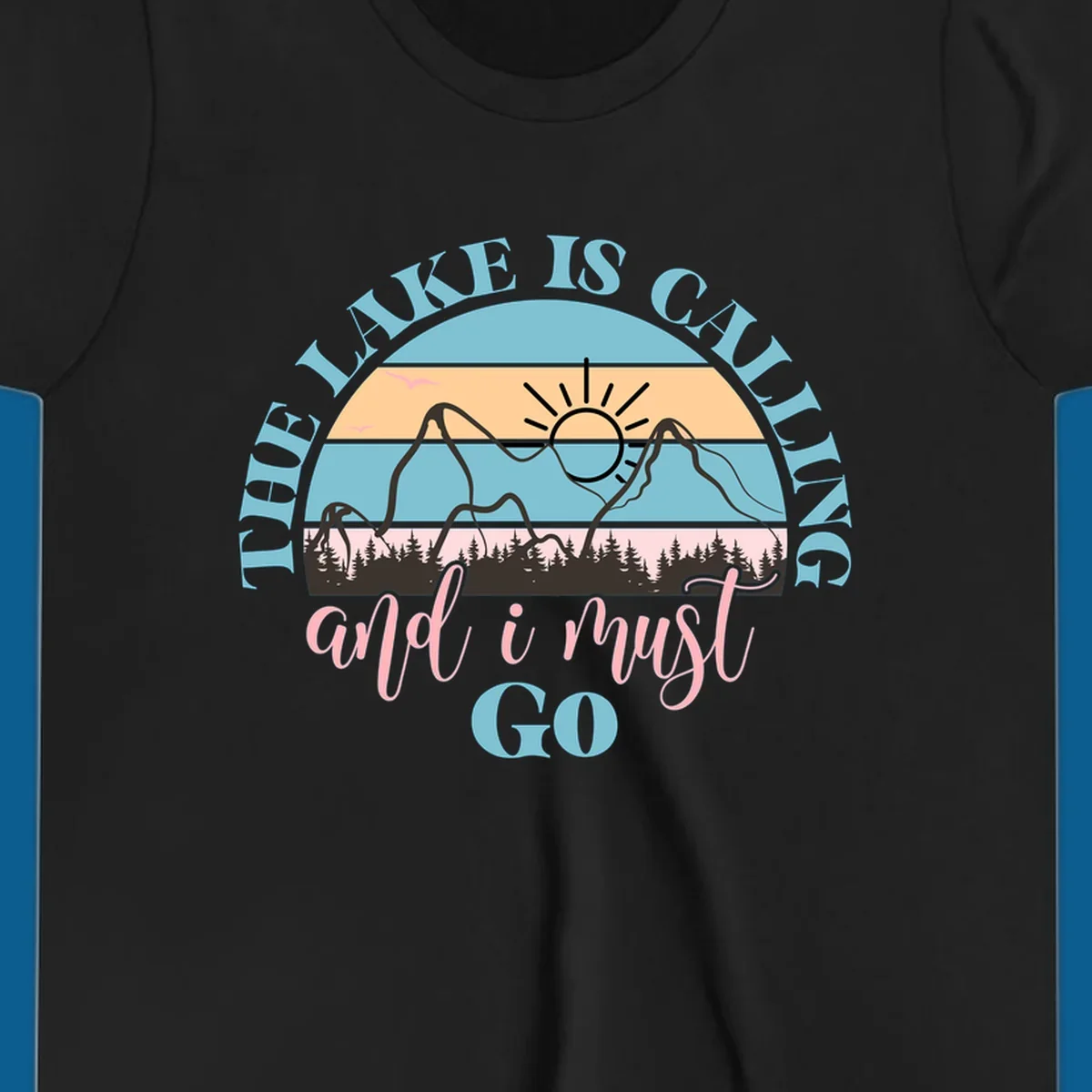 The Lake Is Calling And I Must Go text with mountain and sunset illustration.