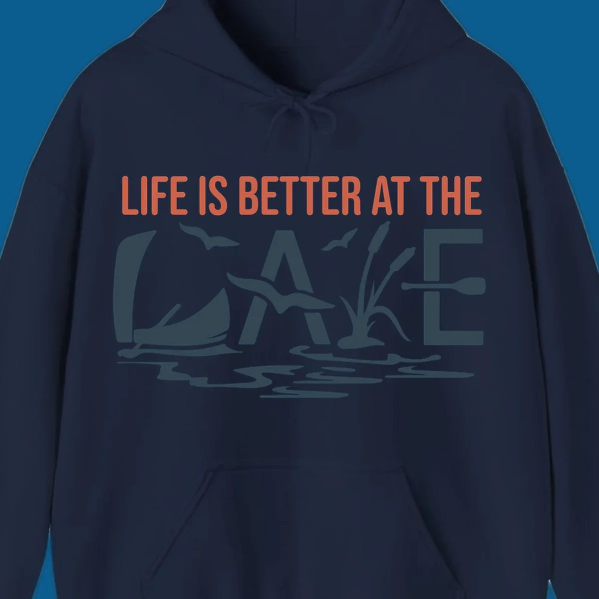Graphic text design 'LIFE IS BETTER AT THE LAKE' with sailboat, birds, cattails, and paddle elements.