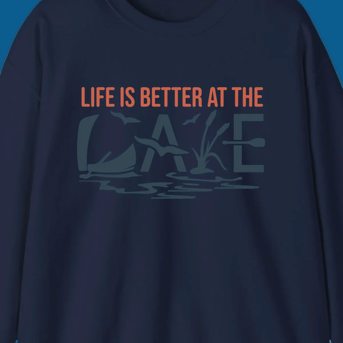 Graphic text design 'LIFE IS BETTER AT THE LAKE' with sailboat, birds, cattails, and paddle elements.