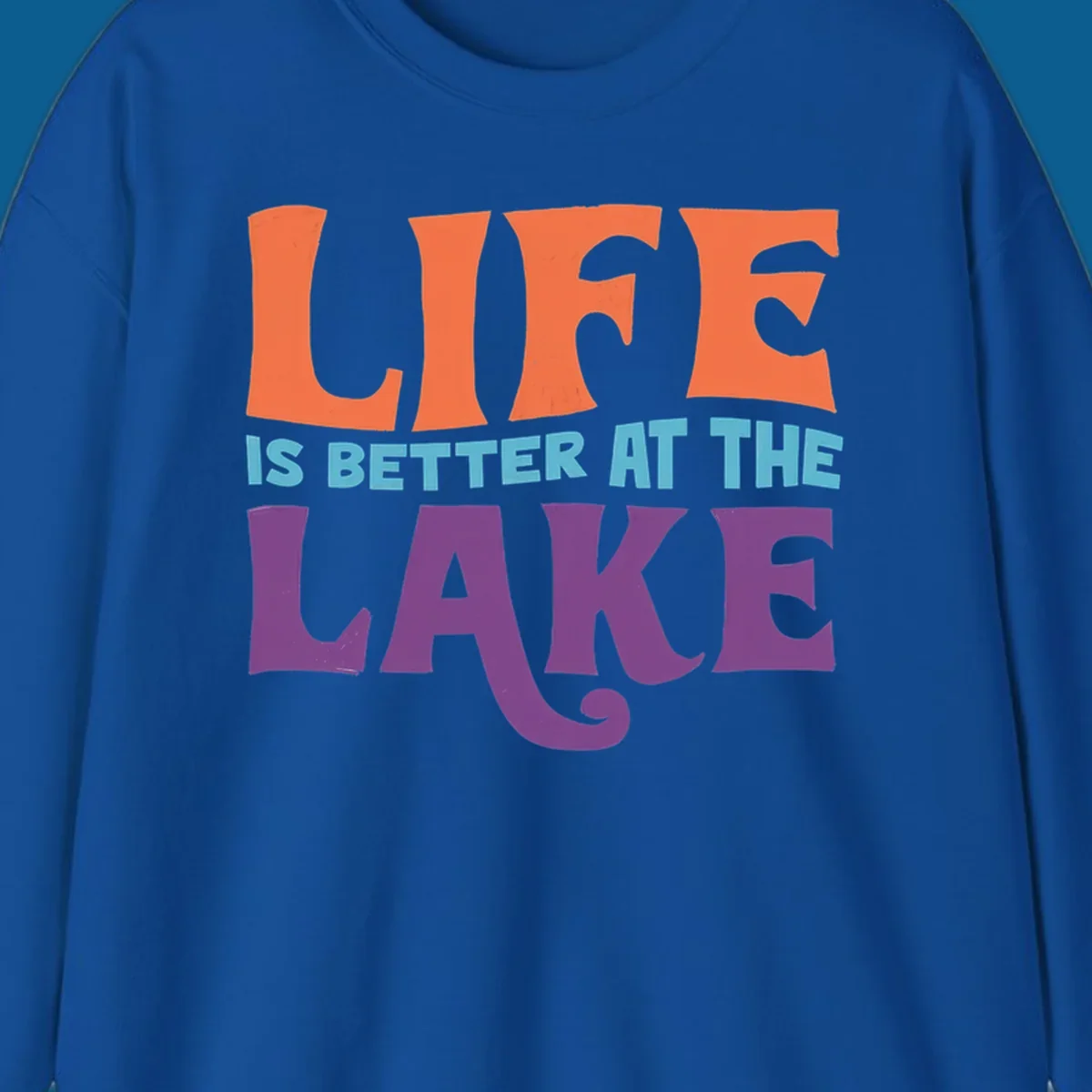 Retro typography design stating "LIFE IS BETTER AT THE LAKE" in orange, teal, and purple.