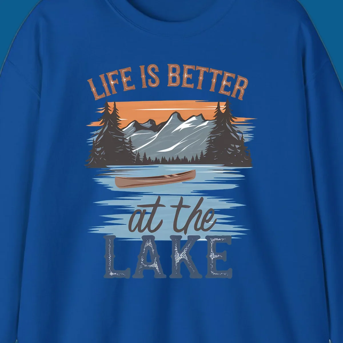 Life is better at the lake scenic design with mountains, canoe, and text.
