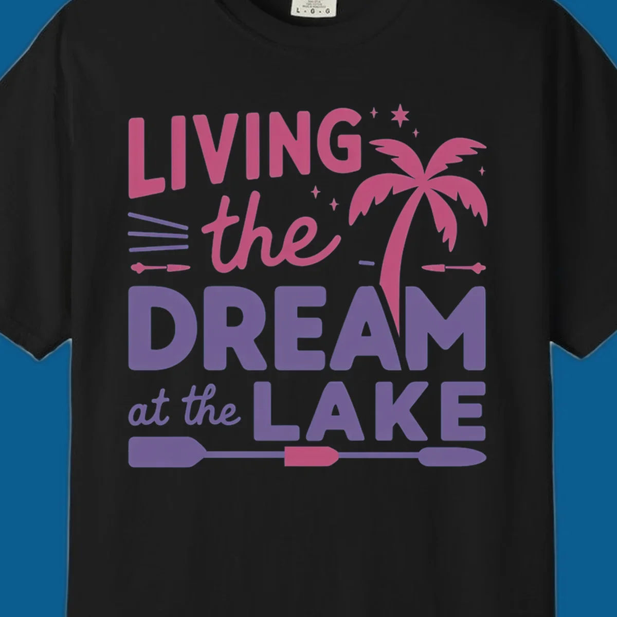 Living the dream at the lake text with palm tree and oars graphic
