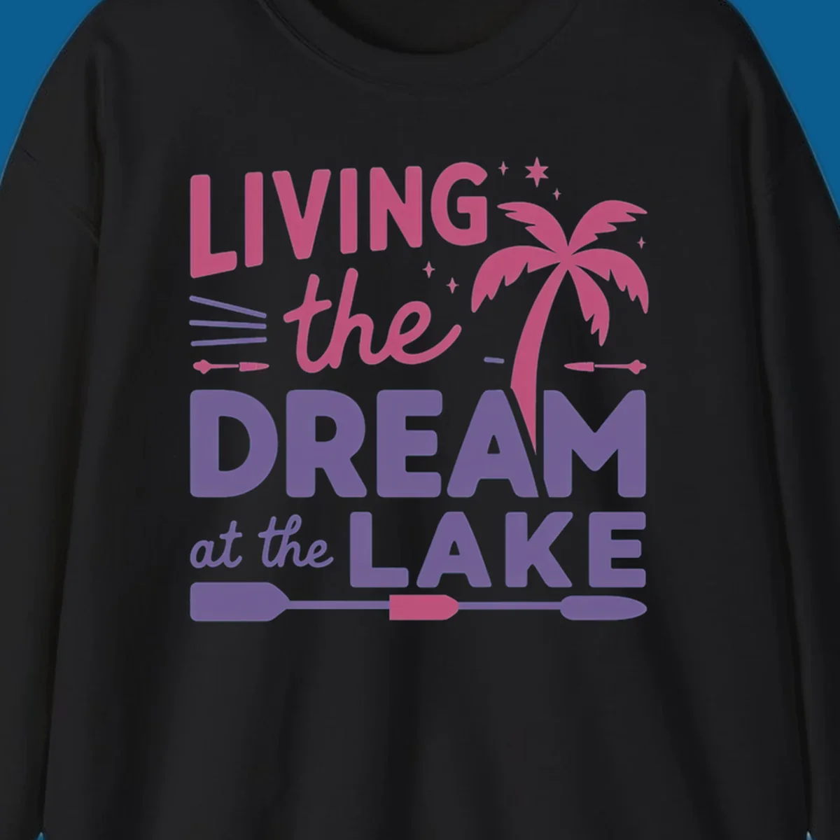 Living the dream at the lake text with palm tree and oars graphic