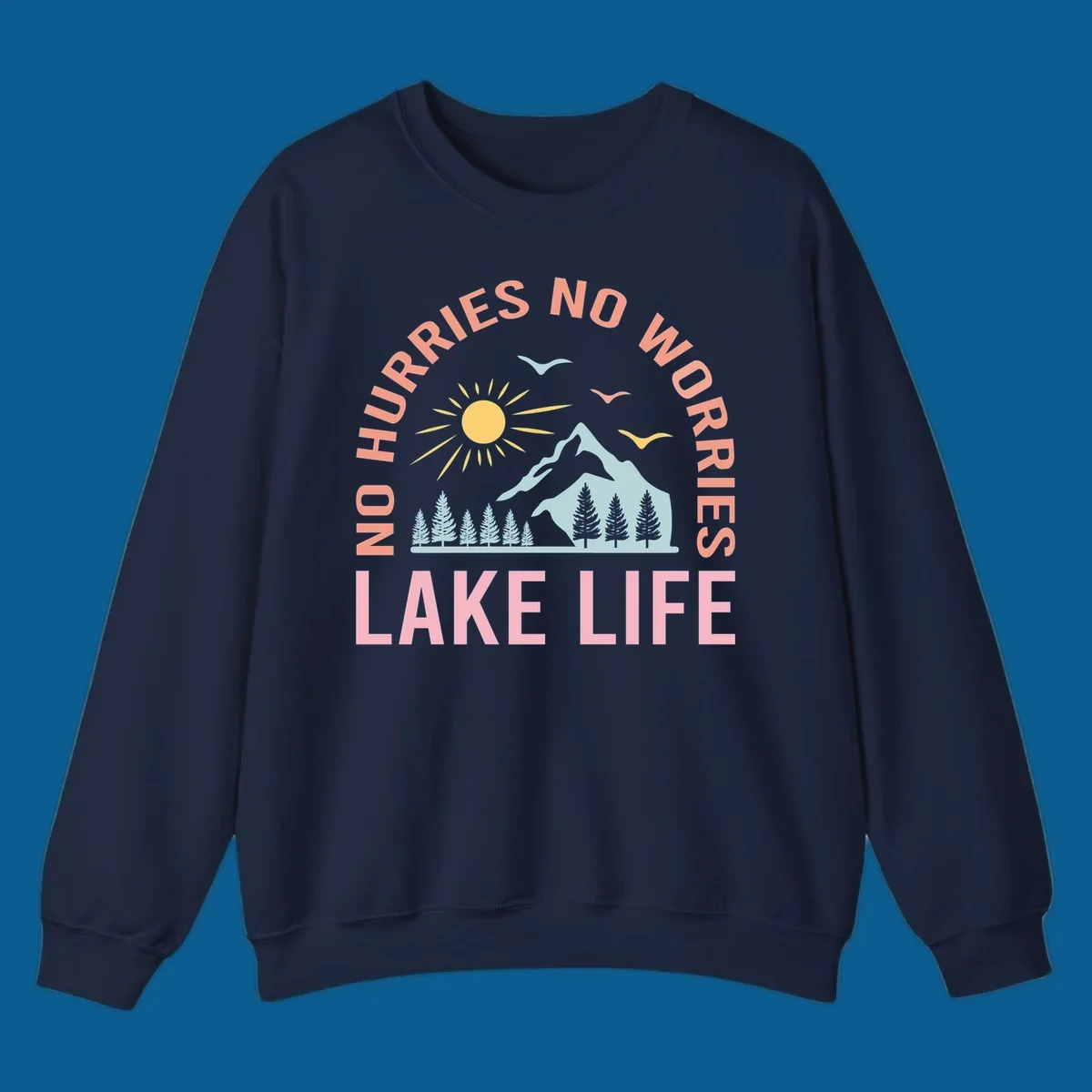 Lake life scenic design with mountains, sun, trees, and no worries text.