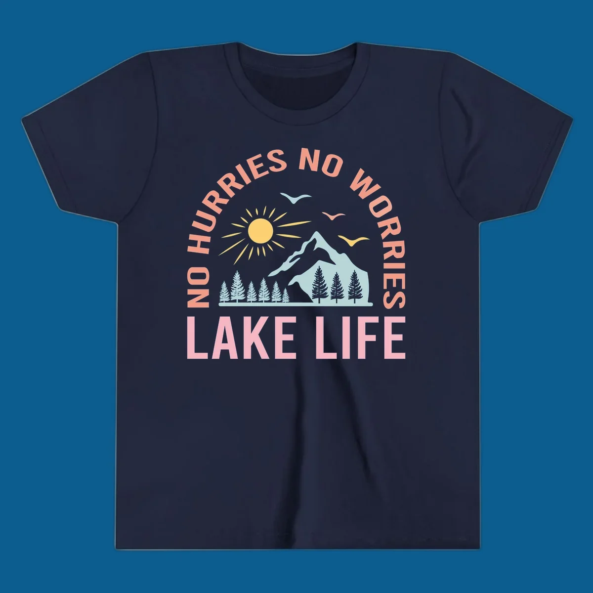 Lake life scenic design with mountains, sun, trees, and no worries text.