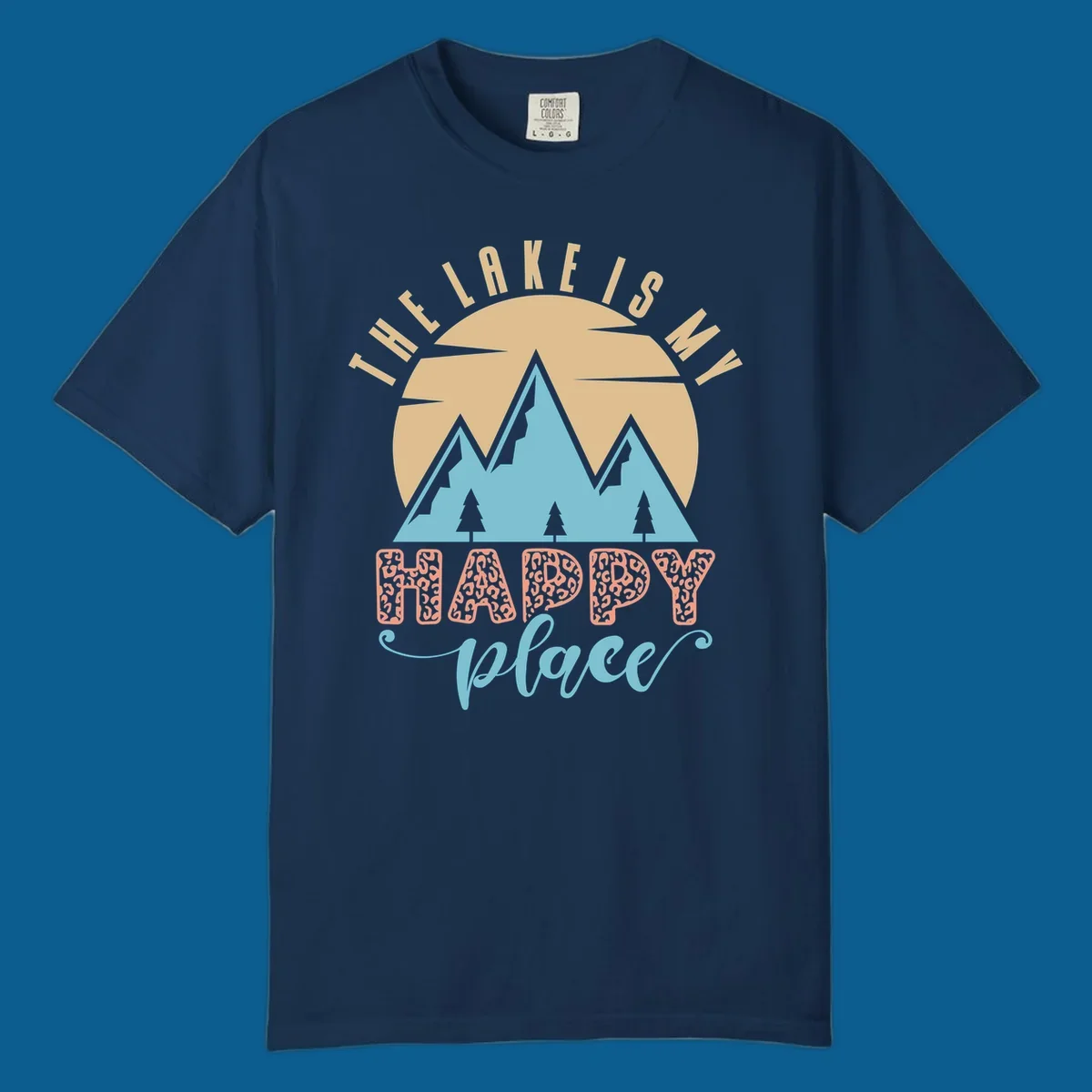 Illustration of mountains and sun with text 'The Lake Is My Happy Place' and leopard print.
