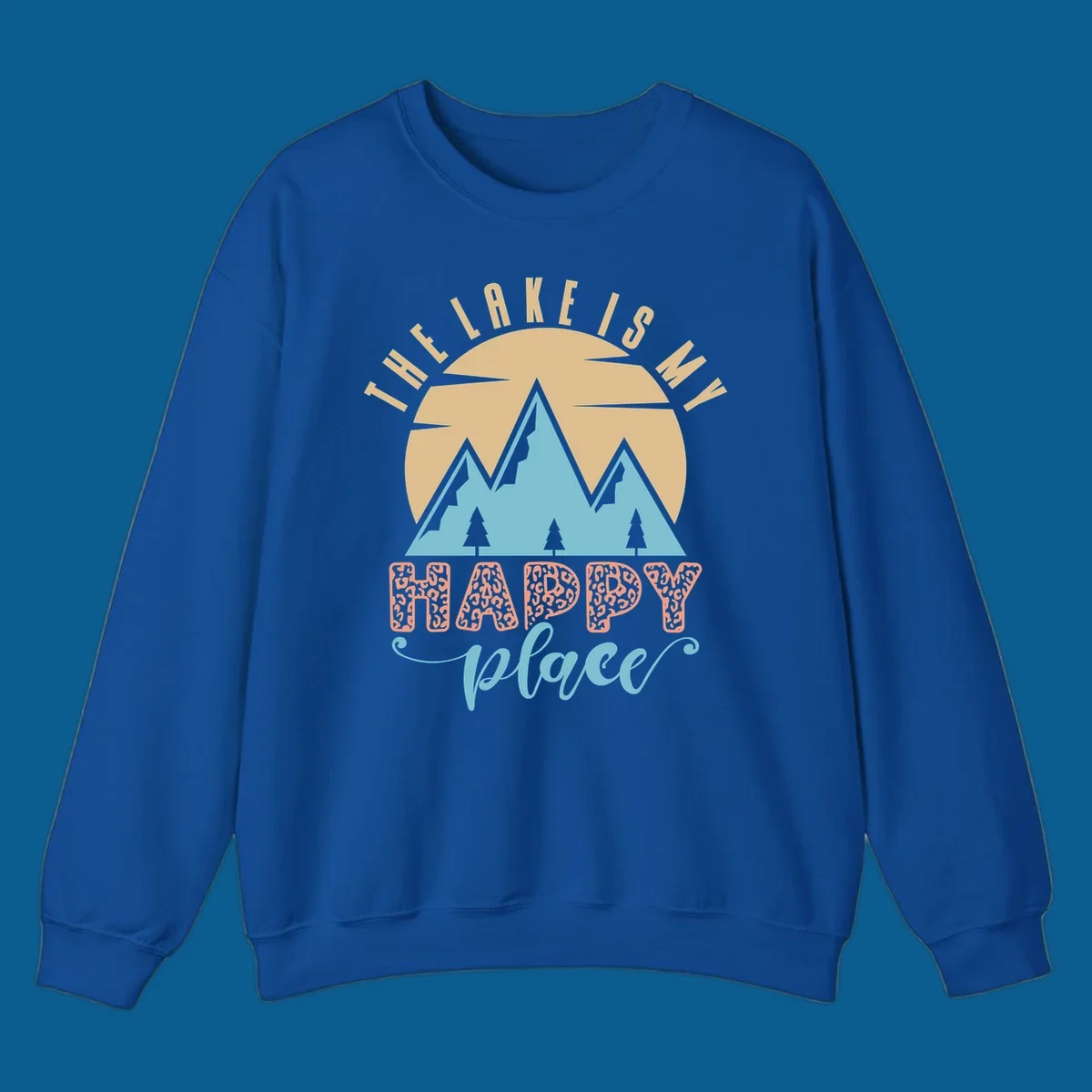 Illustration of mountains and sun with text 'The Lake Is My Happy Place' and leopard print.