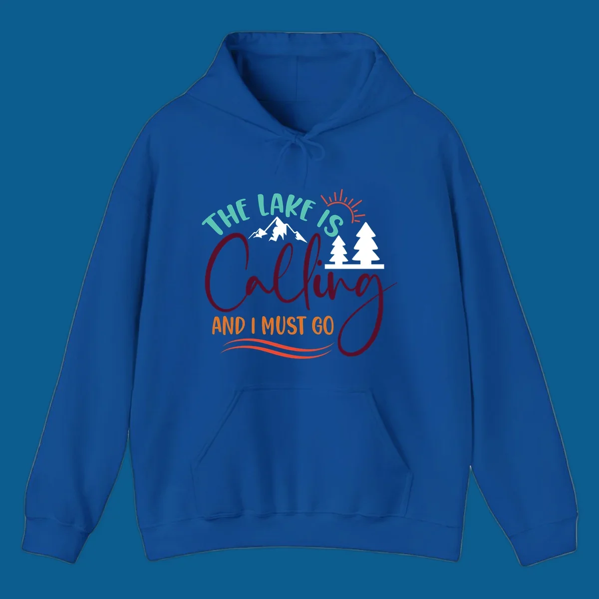 The Lake Is Calling And I Must Go nature graphic with mountains, trees, and sun rays.