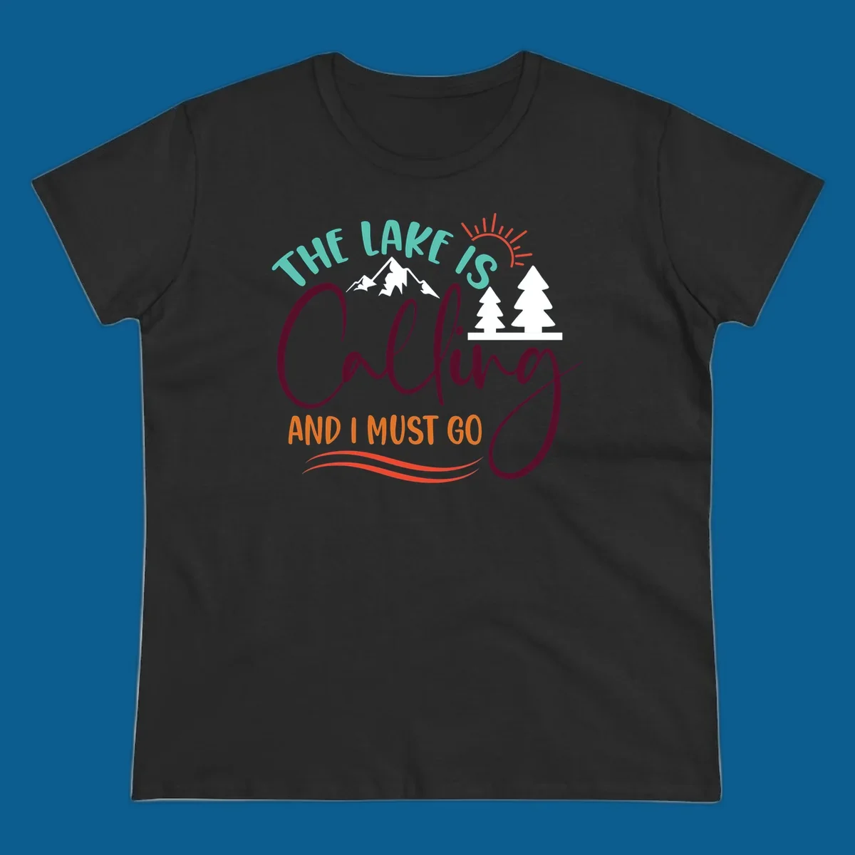 The Lake Is Calling And I Must Go nature graphic with mountains, trees, and sun rays.
