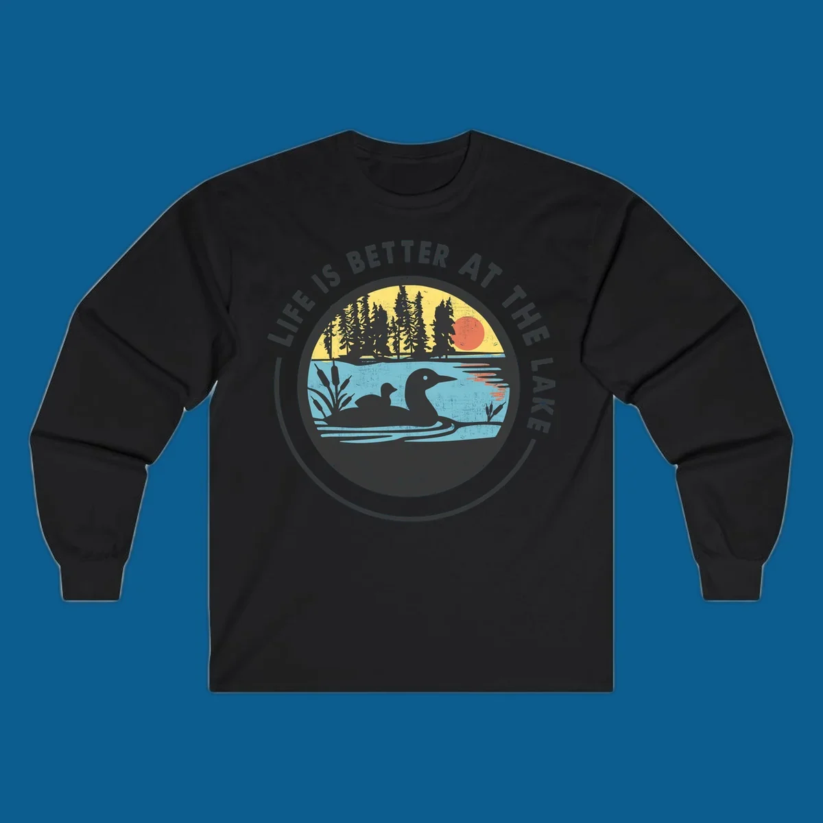Circular lake scene with loons and trees, text "Life Is Better At The Lake".
