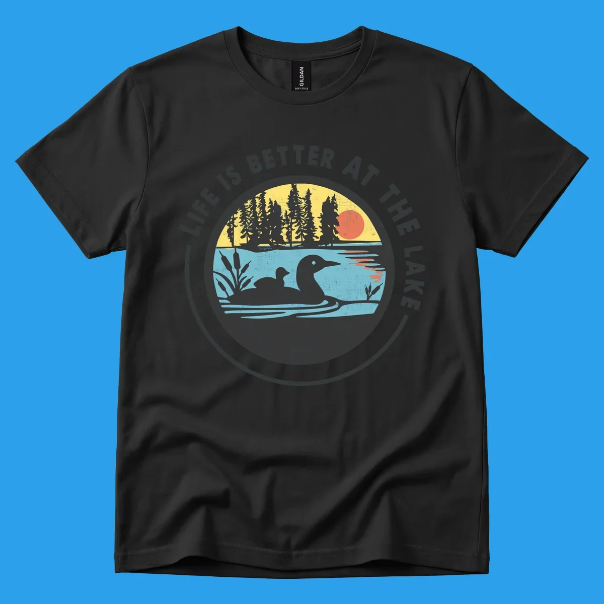 Circular lake scene with loons and trees, text "Life Is Better At The Lake".