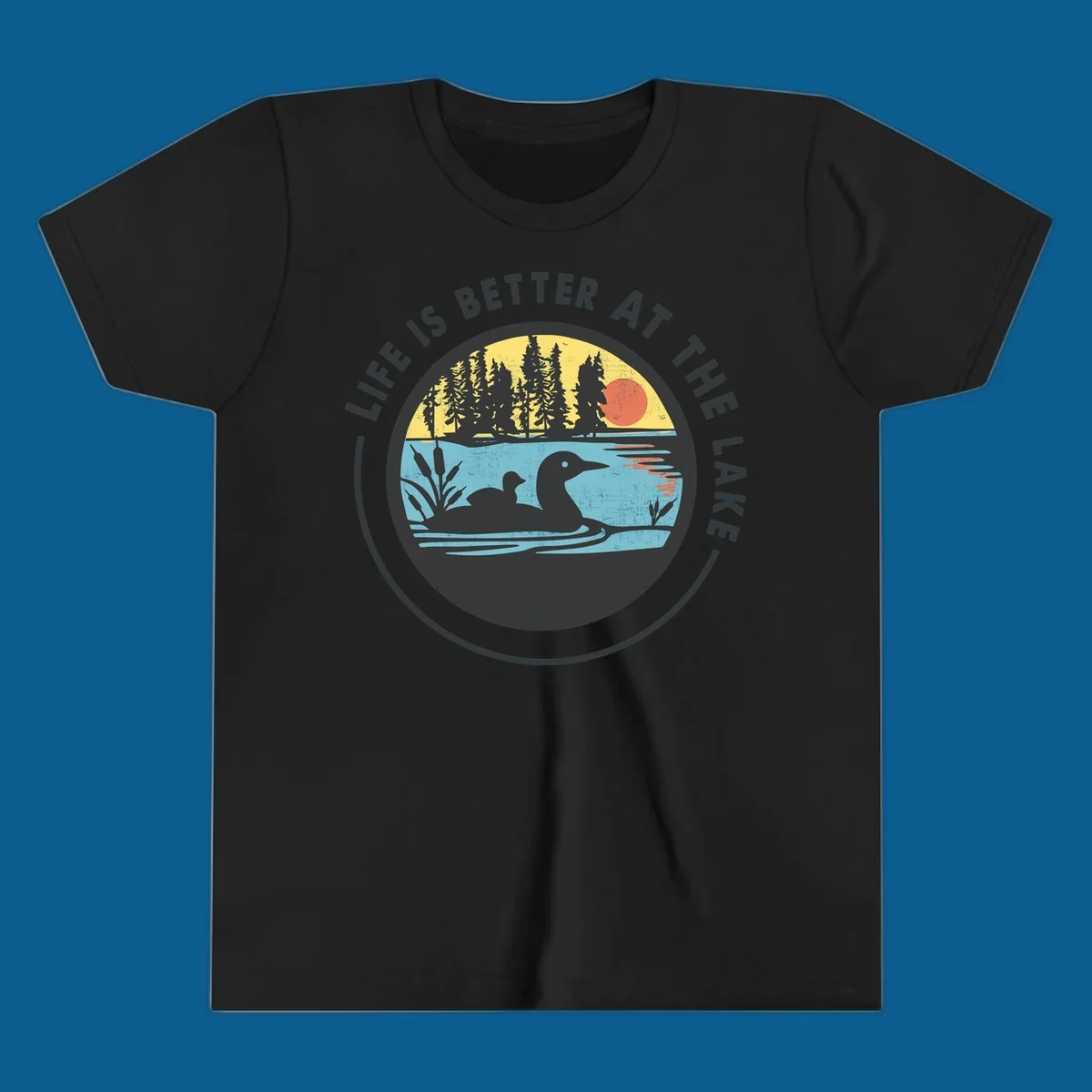 Circular lake scene with loons and trees, text "Life Is Better At The Lake".