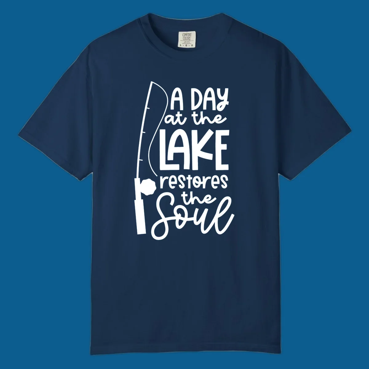 Fishing pole with text "A Day at the Lake Restores the Soul", lake-life concept.