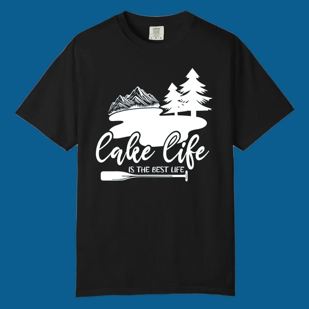 Lake life is the best life design with mountains, trees, lake, and paddle graphic.