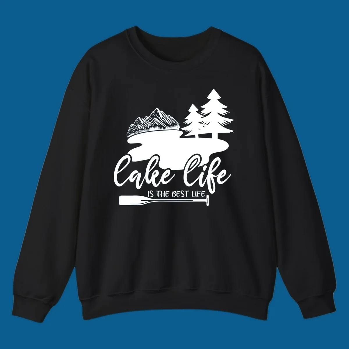 Lake life is the best life design with mountains, trees, lake, and paddle graphic.