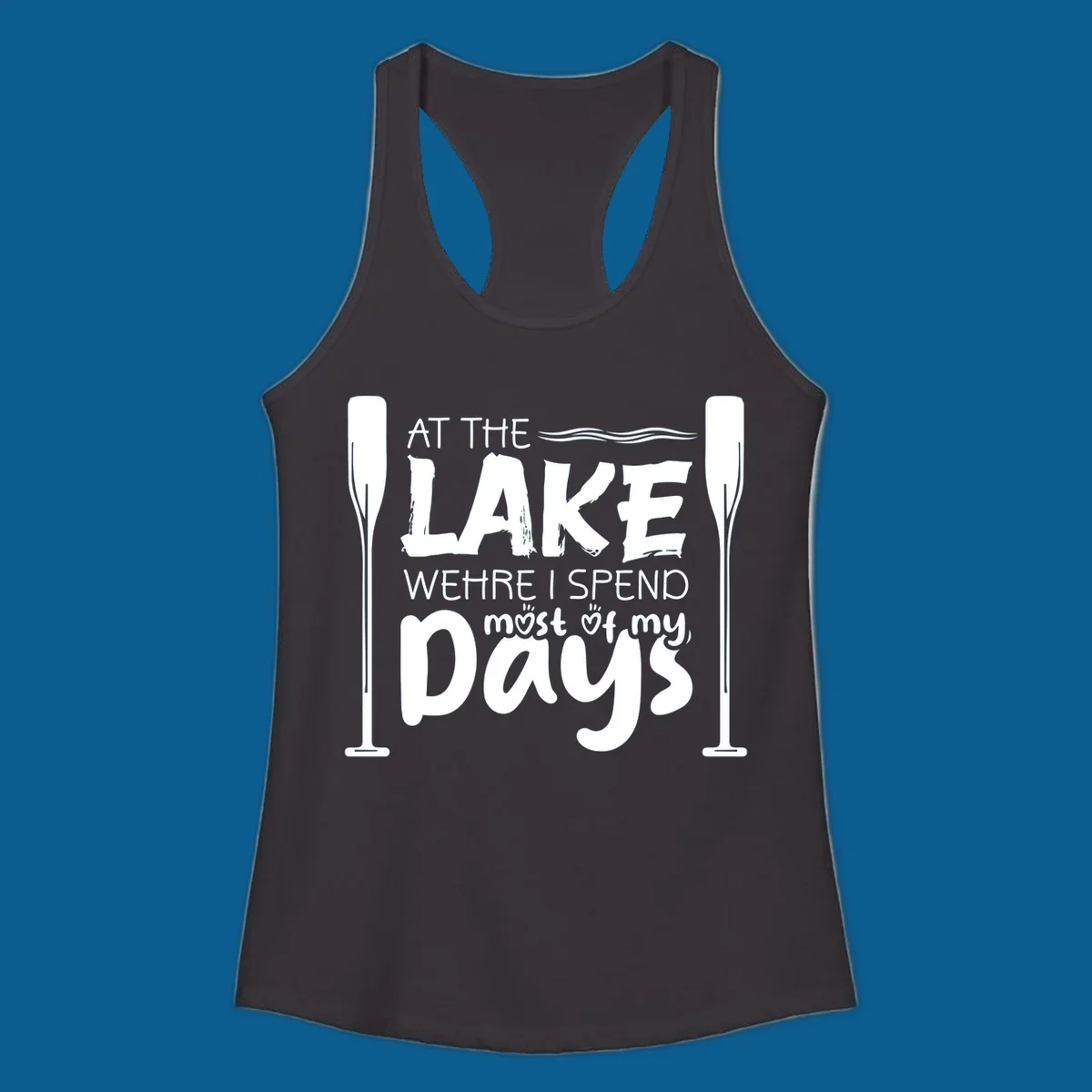 Text design "At The Lake Where I Spend Most Of My Days" with paddles and waves, lake-life-days concept.