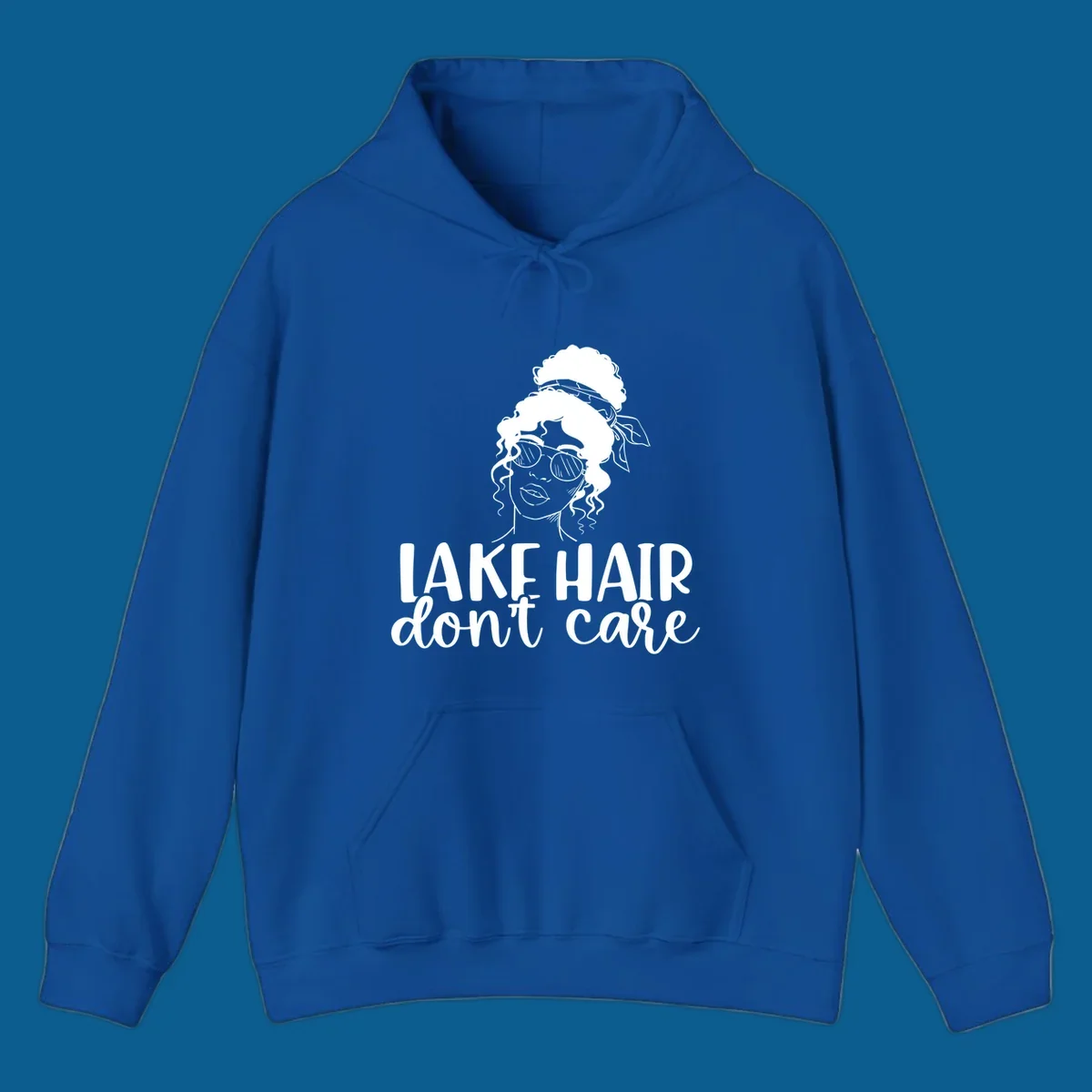 Illustration of a woman with sunglasses and messy bun, with text 'Lake Hair Don't Care'.