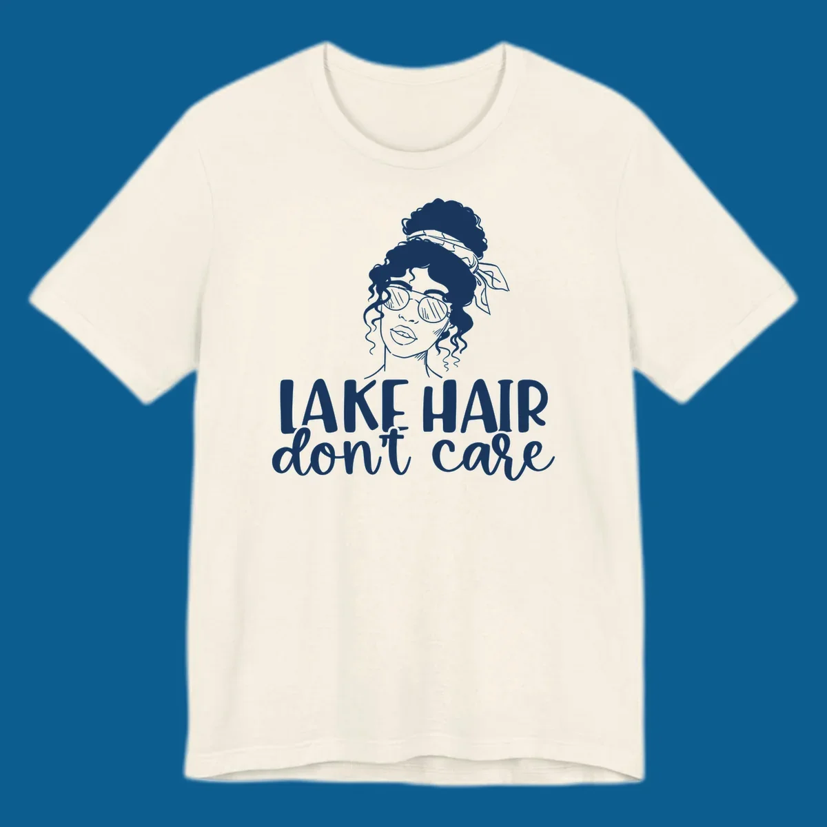 Illustration of a woman with sunglasses and messy bun, with text 'Lake Hair Don't Care'.