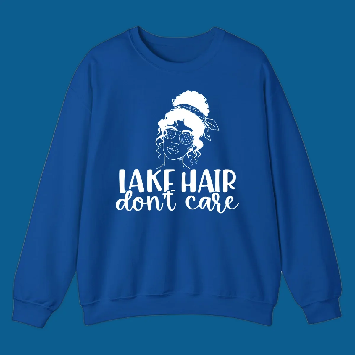 Illustration of a woman with sunglasses and messy bun, with text 'Lake Hair Don't Care'.