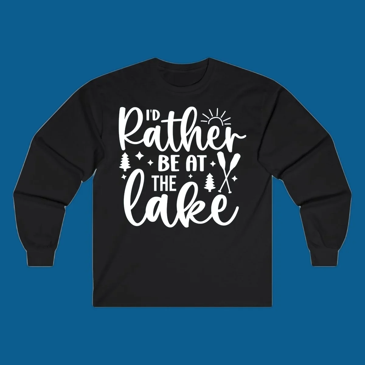 I'd Rather Be At The Lake typography design with sun rays, trees, and oars.