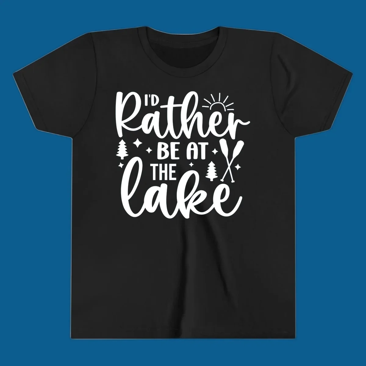 I'd Rather Be At The Lake typography design with sun rays, trees, and oars.