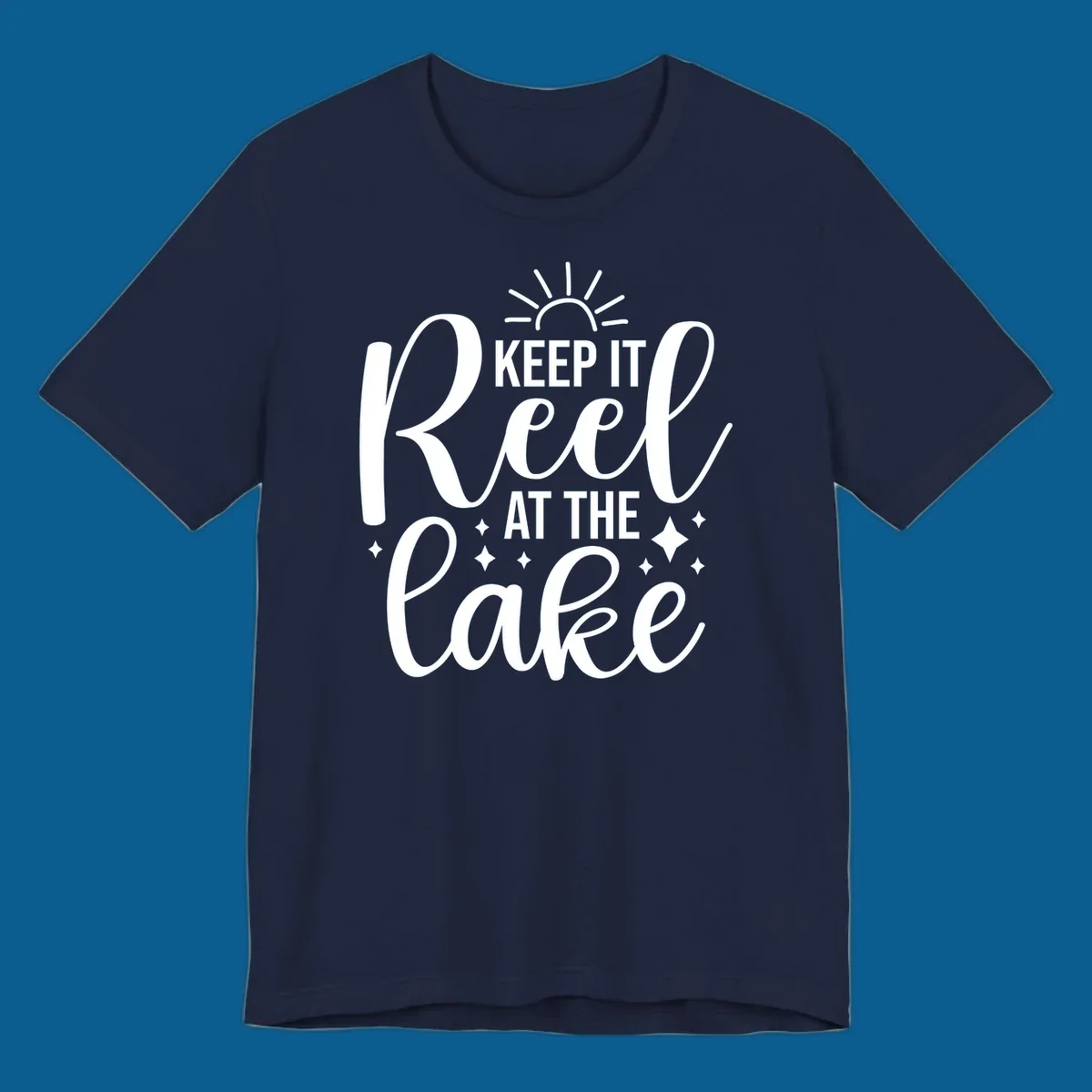 Keep It Reel At The Lake design with sun rays and sparkles, a lakeside lifestyle graphic.