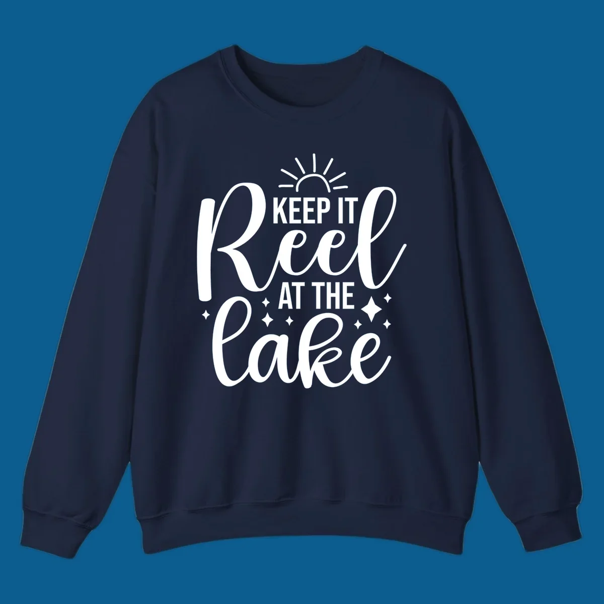 Keep It Reel At The Lake design with sun rays and sparkles, a lakeside lifestyle graphic.