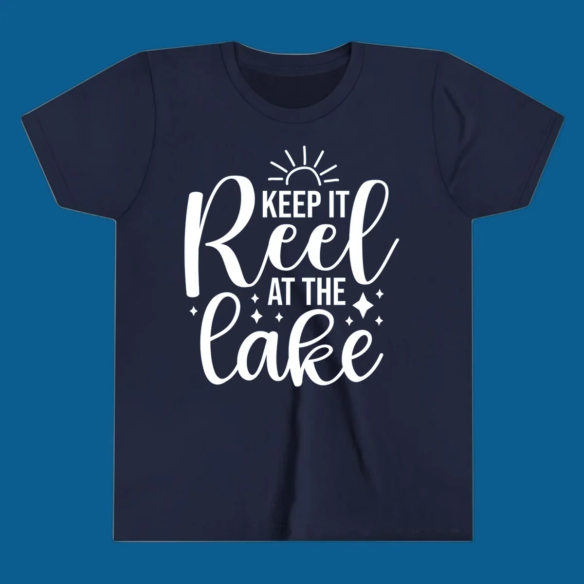 Keep It Reel At The Lake design with sun rays and sparkles, a lakeside lifestyle graphic.