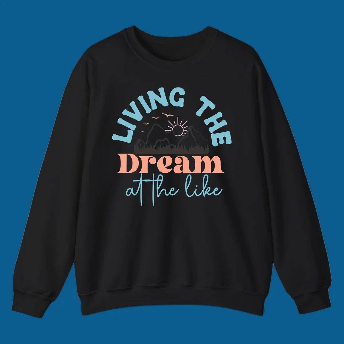 Illustration of mountains with a sunrise and birds above the text 'Living The Dream At The Like'.