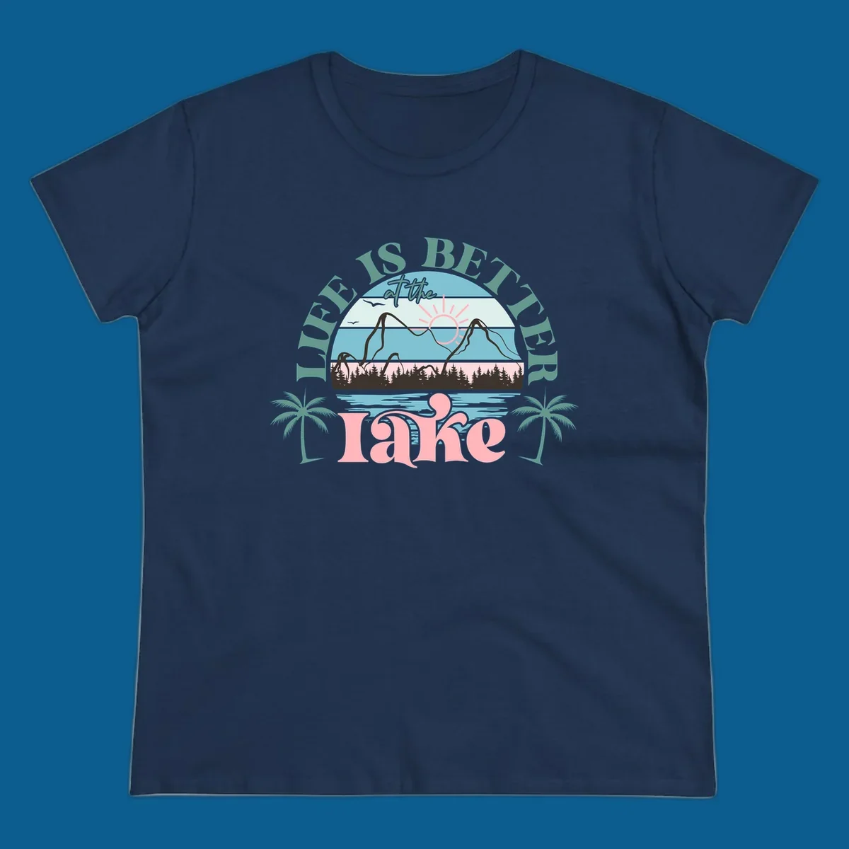 Life is better at the lake scenic design with mountains, trees, lake, and palm trees.