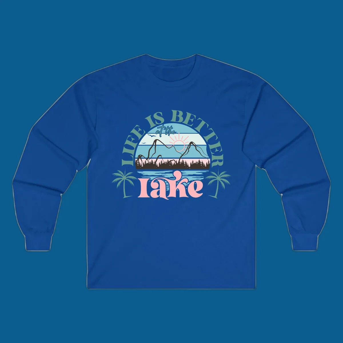 Life is better at the lake scenic design with mountains, trees, lake, and palm trees.