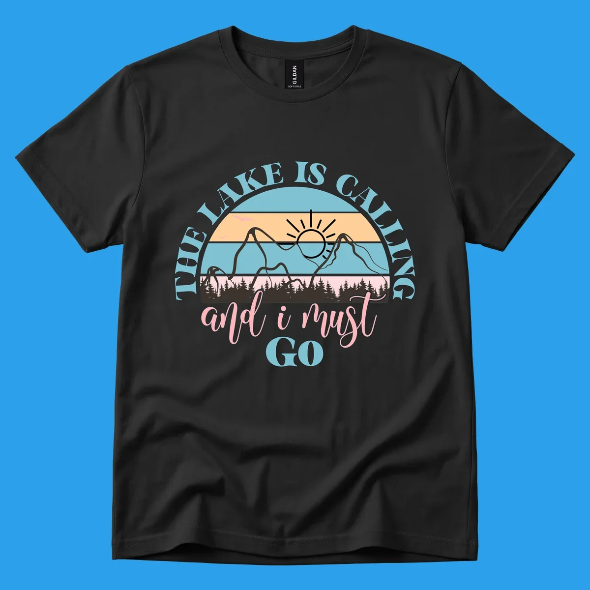 The Lake Is Calling And I Must Go text with mountain and sunset illustration.