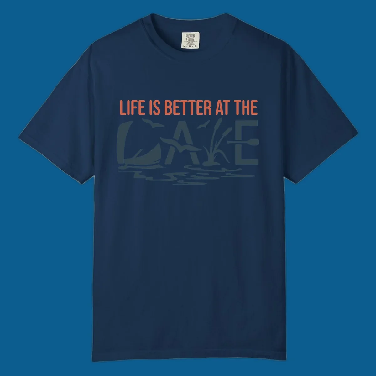 Graphic text design 'LIFE IS BETTER AT THE LAKE' with sailboat, birds, cattails, and paddle elements.