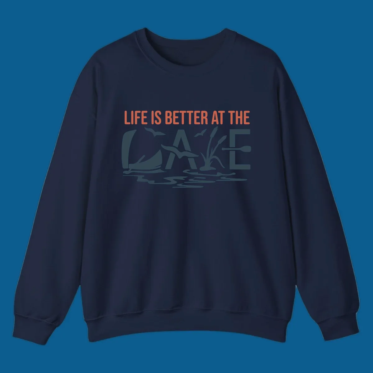 Graphic text design 'LIFE IS BETTER AT THE LAKE' with sailboat, birds, cattails, and paddle elements.